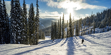 Skiers on a run at Sun Peaks ski resort, Kamloops, British Columbia, Canada