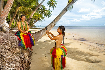 Two young women in traditional outfits for cultural ceremonies taking a photo with a smartphone on the island of Yap, Yap, Micronesia