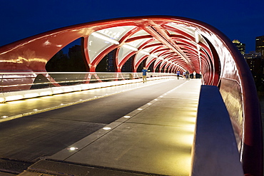 Glowing lights inside a pedestrian red metal bridge at night, Calgary, Alberta, Canada