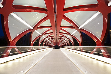 Glowing lights inside a pedestrian red metal bridge at night, Calgary, Alberta, Canada