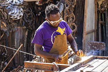 Welder at the Medeber Market, where artisans recycle old tyres and tins to make new artifacts, Asmara, Central Region, Eritrea