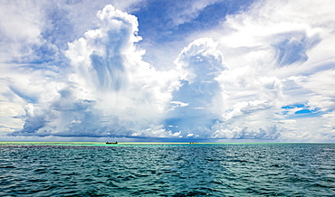 Turquoise water of the Pacific Ocean with a cloud-filled big sky overhead, Malolo Island, Fiji