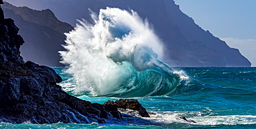 Large ocean wave crashes into rock along the Na Pali Coast, Kauai, Hawaii, United States of America