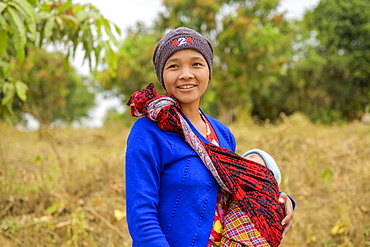 Young mother standing with her baby in a sling, Taungyii, Shan State, Myanmar