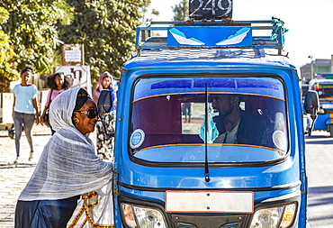 Woman by an auto rickshaw talking to the driver through the window, Wukro, Tigray Region, Ethiopia