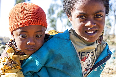 Ethiopian girl carrying a little boy, Simien Mountains, Amhara Region, Ethiopia