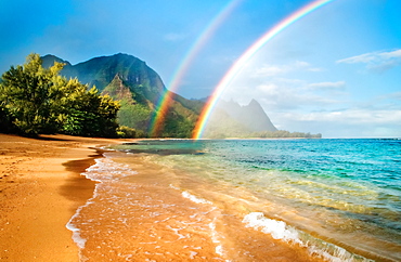 A double rainbow over the coastline of a Hawaiian island with mountains and turquoise water, Haena, Kauai, Hawaii, United States of America