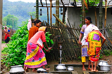 Women pumping water from a hand pump, Jorhat, Assam, India, Asia