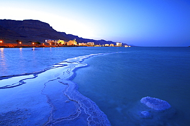 Salt deposit in foreground looking towards Ein Bokek, Ein Bokek, Dead Sea, Israel, Middle East