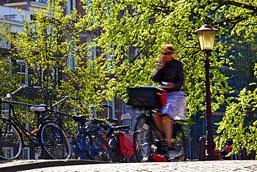 Cyclist on bridge over canal, Amsterdam, Netherlands, Europe