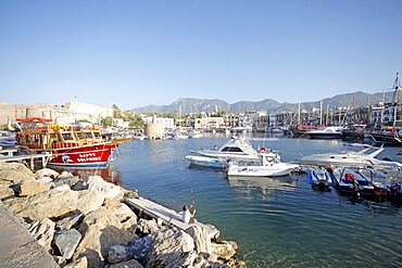 Boy fishing and boats in harbour, Kyrenia, Northern Cyprus, Mediterranean, Europe