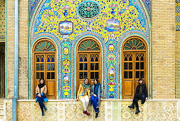 Group of young Iranian women seated in front of ceramic tiles, Golestan Palace, UNESCO World Heritage Site, Tehran, Islamic Republic of Iran, Middle East