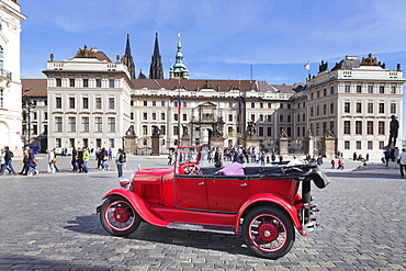 Red Oldtimer for tourist sightseeing tours in front of the First courtyard, Hradcany Square, Castle Hradcany and St Vitus cathedral, Castle District, UNESCO World Heritage Site, Prague, Bohemia, Czech Republic, europe