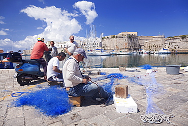 Fishermen at the harbour, old town with castle, Gallipoli, Lecce province, Salentine Peninsula, Puglia, Italy, Europe