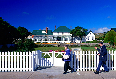 People walking past Government House in Port Stanley, Falkland Islands