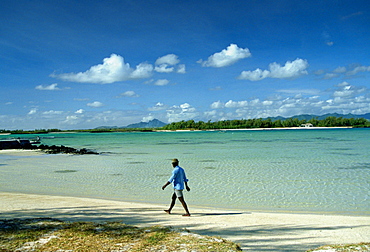 Man walking alone one the beach in Mauritius