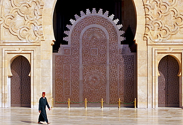 Man walking outside Hassan II Mosque in Casablanca, Morocco