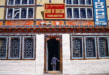 Small child standing in the doorway of the bank in Paro, Bhutan