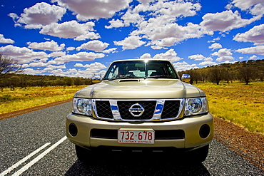 Four-wheel-drive Nissan Patrol vehicle on road in the Red Centre, Australia