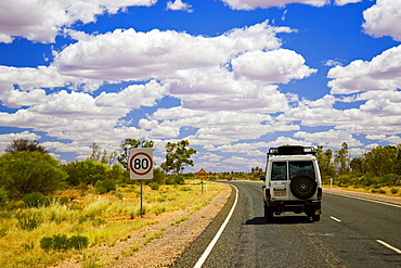 Four-wheel-drive vehicle on road in the Red Centre, Northern Territory, Australia