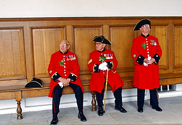 Chelsea Pensioners, dressed in their traditional uniform and red jacket and black tricorn hat, sitting inside the Royal Hospital in Chelsea during the Founder's Day Parade.