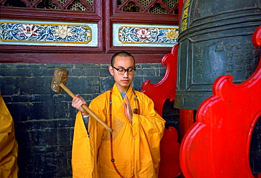 Buddist monk ringing the Huating Temple gong, China