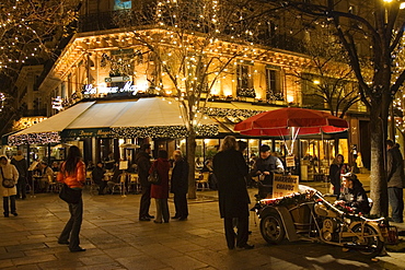 Roasted chestnut street seller outside Les Deux Magots Cafe and Restaurant, Boulevard St Germain, Paris, France