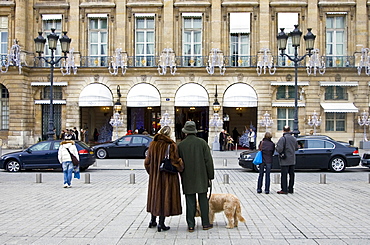 Couple with dog gaze at Ritz Hotel in Place Vendome, Central Paris, France