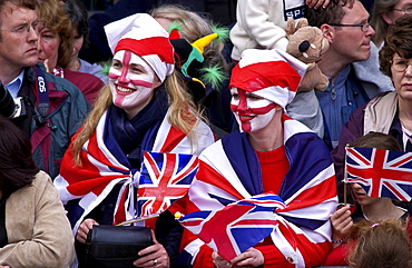 Enthusiastic patriots wearing Union Jack flags and England flag symbols painted on their faces, London, England