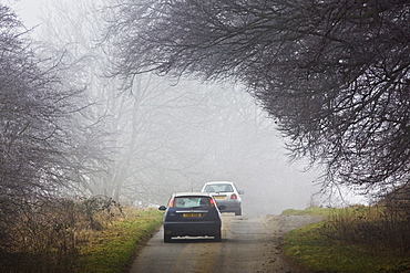 Cars drive along foggy road, Oxfordshire,  United Kingdom