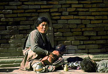 A woman cradles her baby in the streets, Nepal, Asia