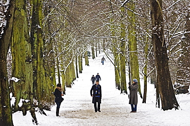 People walk across snow-covered Hampstead Heath, London, United Kingdom