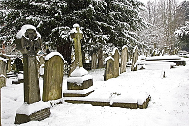 Snow covered gravestones in Hampstead Parish churchyard, London, United Kingdom