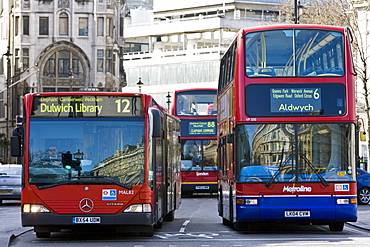 Public transport buses travel in heavy traffic in Trafalgar Square, London city centre, England, United Kingdom