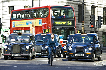 Biker in front of heavy traffic in Trafalgar Square, downtown London city centre, England, United Kingdom