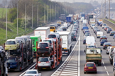 Car transporter lorries travelling among congested traffic on M1 motorway in Hertfordshire, United Kingdom