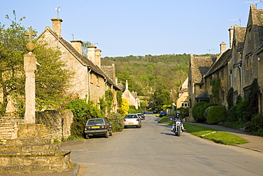 Motorcyclist rides through Stanton village, Gloucestershire,  The Cotswolds, United Kingdom