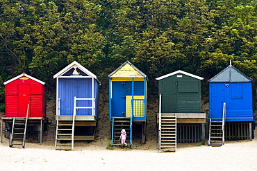 Young girl explores beach huts in Wells-Next-The-Sea, Norfolk, United Kingdom