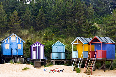 Couple sunbathe outside their beach hut in Wells-Next-The-Sea, Norfolk, United Kingdom