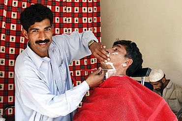 Man visits barber shop in village of Pattika, Pakistan