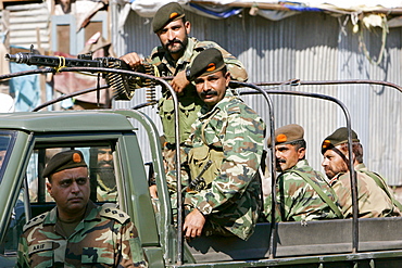 Armed Pakistani soldiers in open top vehicle with machine gun in village of Pattika, Pakistan