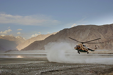 Helicopter lands on heliport in valleys of Karokoram Mountains, Skardu Valley, North Pakistan