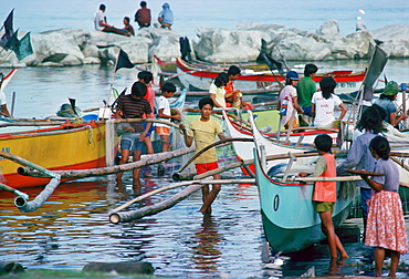 Fishermen bring in their boats and their catch to the fish market in Manila, Philippines