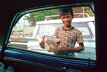 Boy sells cigarettes at car windows in Manila, Philippines