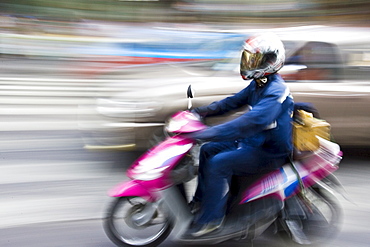 Commuter travelling on a scooter, Bangkok, Thailand