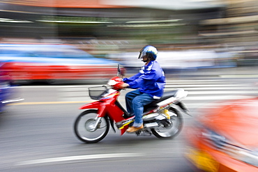 Commuter travelling on a scooter, Bangkok, Thailand