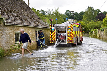 Firemen pump water out of flooded home in Naunton, The Cotswolds, Gloucestershire, England, United Kingdom