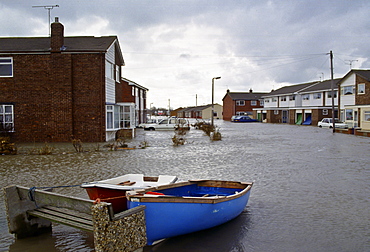 Boats tethered to a stone bench in the flooded town of Towyn in North Wales, UK.