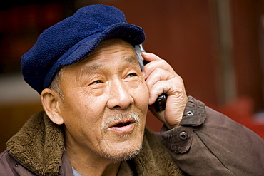 Chinese man chats on a mobile phone, Fuli Old Town, Xingping, China