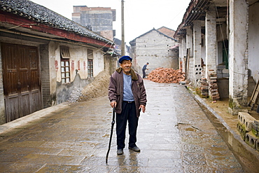 Elderly man with a walking stick in Fuli Old Town, Xingping, China